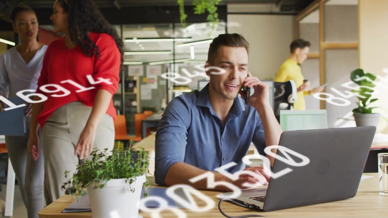 Colega de trabalho atendendo uma ligação e digitando para um plano de negócios, com colegas andando e dados flutuantes.