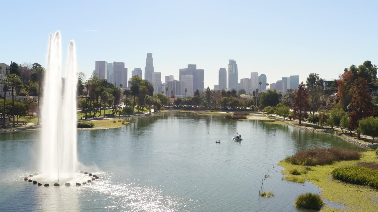 Stunning aerial over a beautiful lake fountain with downtown buildings in the background