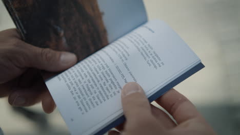 man leafs through a small booklet to read about interesting informations about the location in slovenia