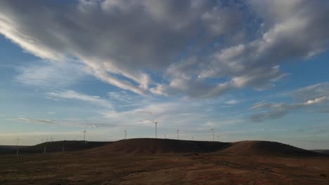 Wind-turbines-over-hills-at-sunset,-Australia