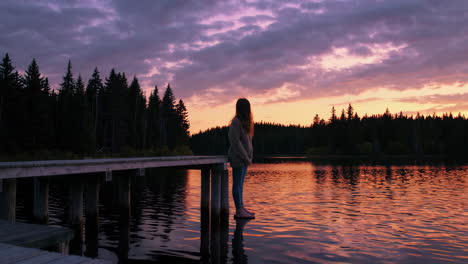 woman on a pier at sunset