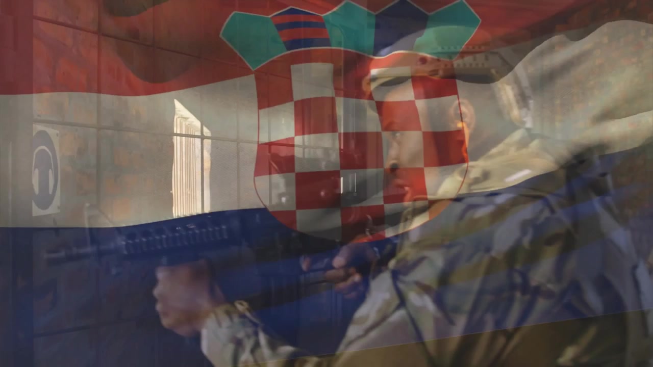 Voják skenuje místnost, poté postupuje k obrannému cvičení, s puškou na rameni pod chorvatskou vlajkou.