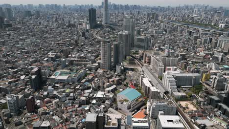 aerial scenic urban drone footage of a neighborhood, streets and buildings in the capital city of tokyo, japan on a sunny day