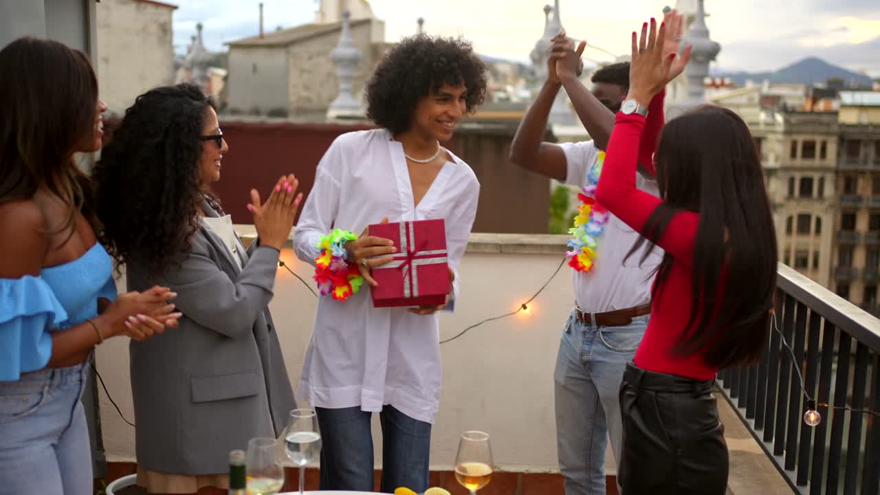 Group of friends celebrating a gift on a rooftop