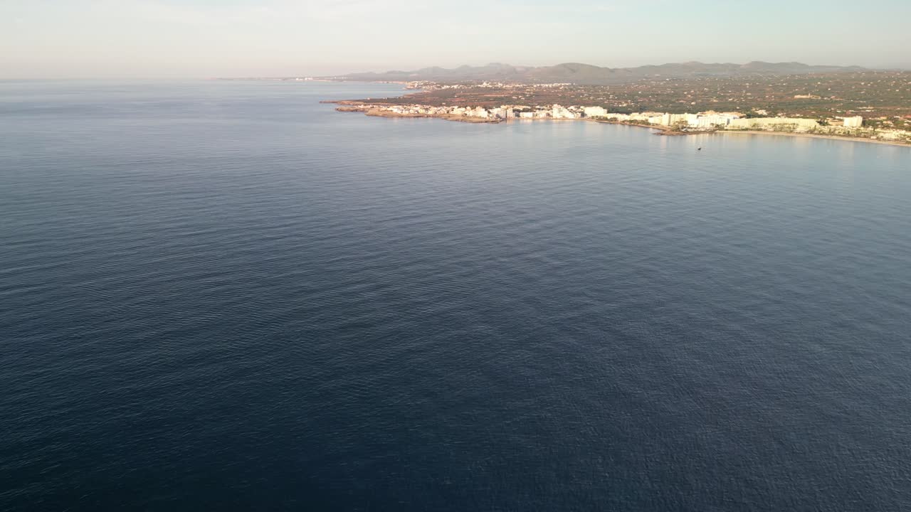 mar prístino con ciudad turística cerca de sa coma en mallorca españa durante el verano