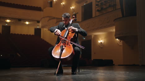 solo of violoncellist on scene of old opera house portrait of cellist in empty philharmonic hall