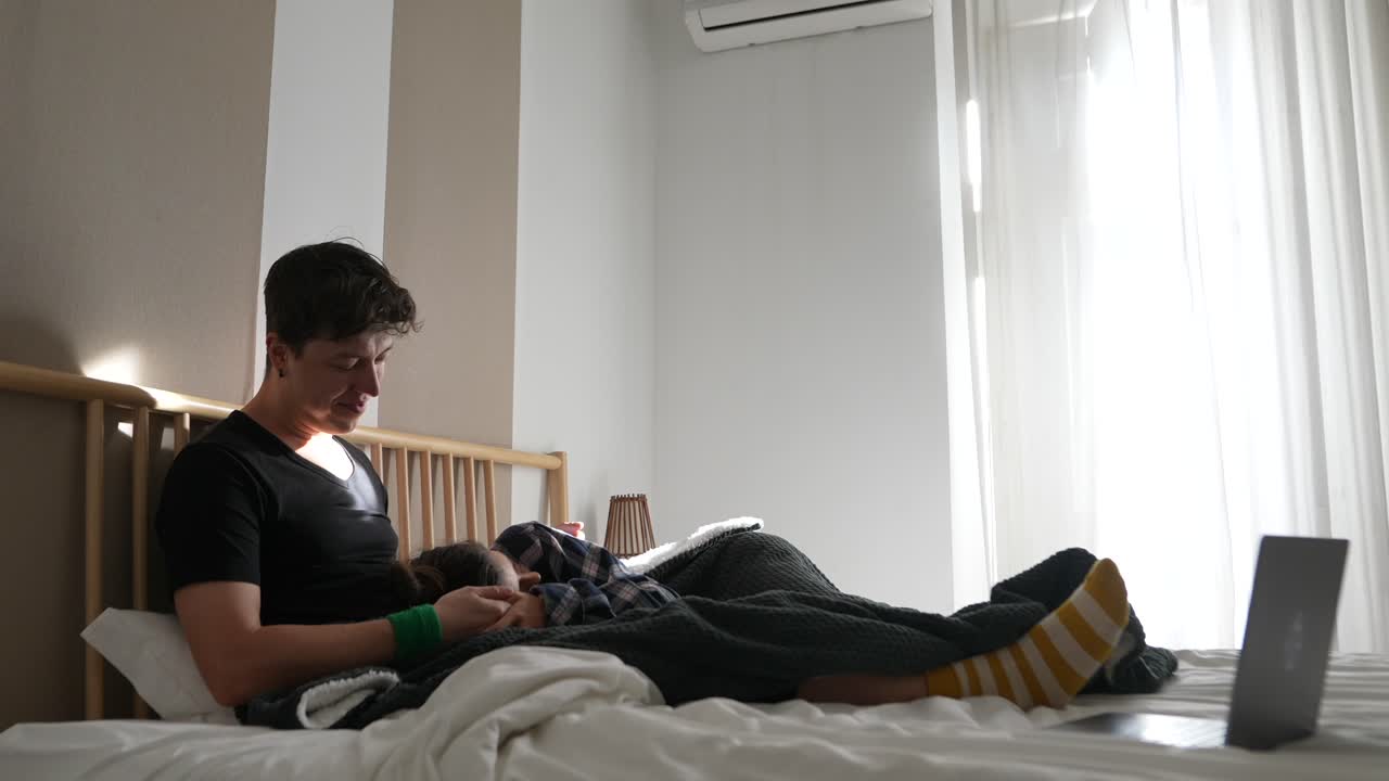 이 침대에서 휴식을 취하고 노트북을 보고 있다