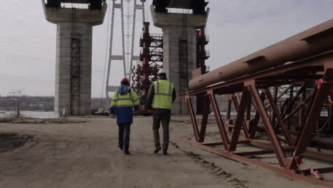 construction workers inspecting bridge construction site