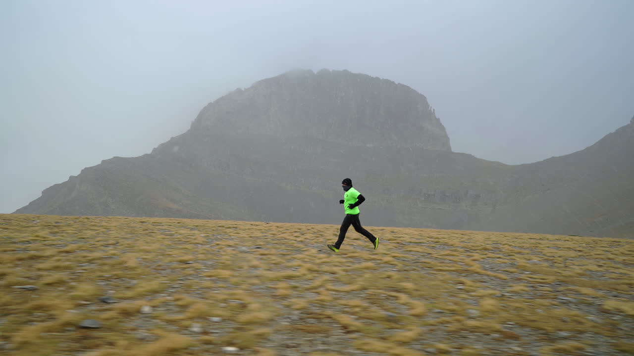 Corredor de trilha de montanha no Planalto das Musas com o Trono de Zeus, acompanhamento lateral de médio alcance em chuva nevada.