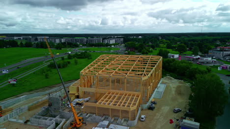 drone aéreo giratorio disparado más bajo la ubicación de la construcción con la casa de pared de madera edificio de esqueleto de marco de paneles en un día nublado