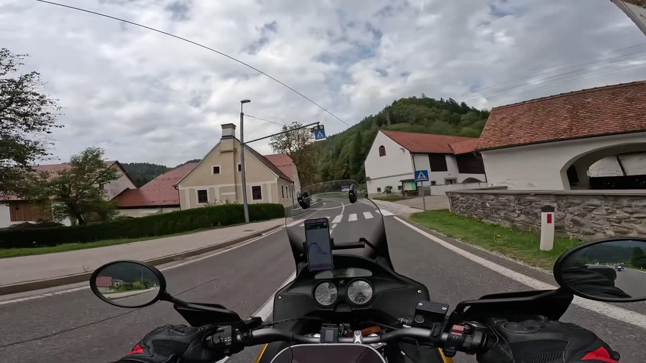 Eerste persoonsperspectief van motorrijden op een landweg in Slovenië, rit door Alpenbergpaslandschap, actiecamera-opname.