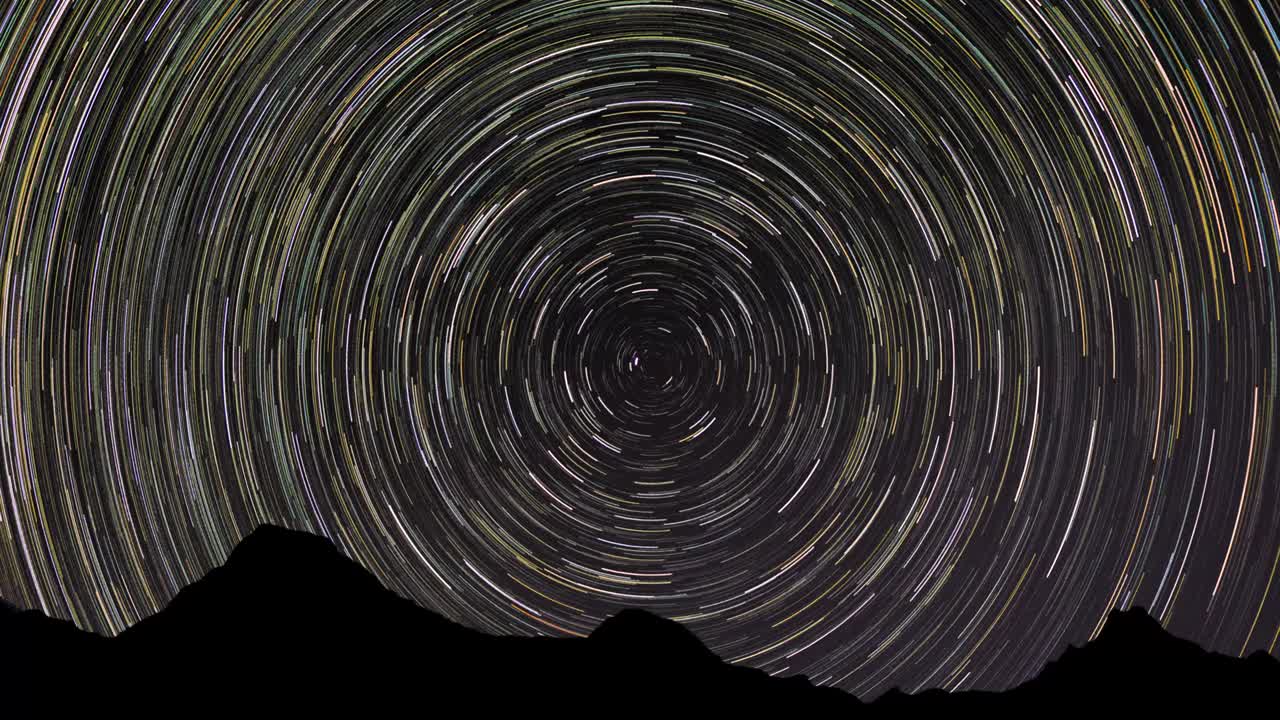 천상의 북극을 둘러싼 별의 흔적의 누적 8시간 길이의 타임 스 (time-lapse of star trails around the celestial north pole with mountain sillout)