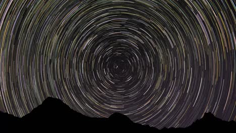 cumulative 8 hour long time-lapse of star trails around the celestial north pole with mountain silloutte