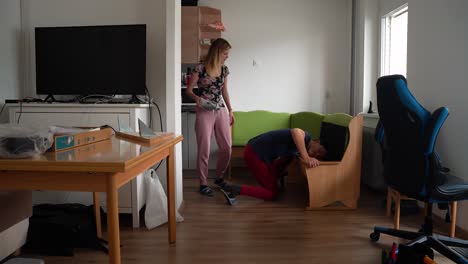 young couple dismanteling a kitchen seat at day time. time lapse