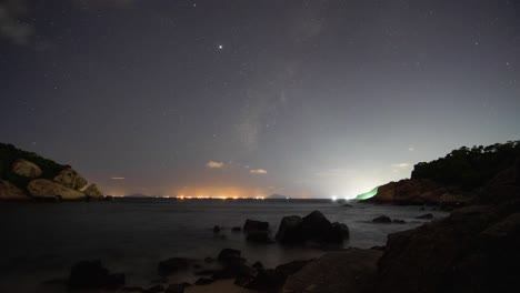 Cheung-Chau-active-harbour-lights-glowing-underneath-fast-night-sky-clouds-timelapse