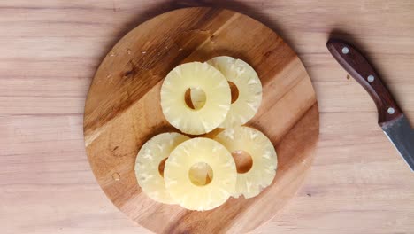 sliced pineapple on a wooden cutting board