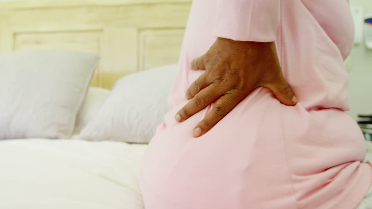 Senior woman having back pain in bedroom 4k
