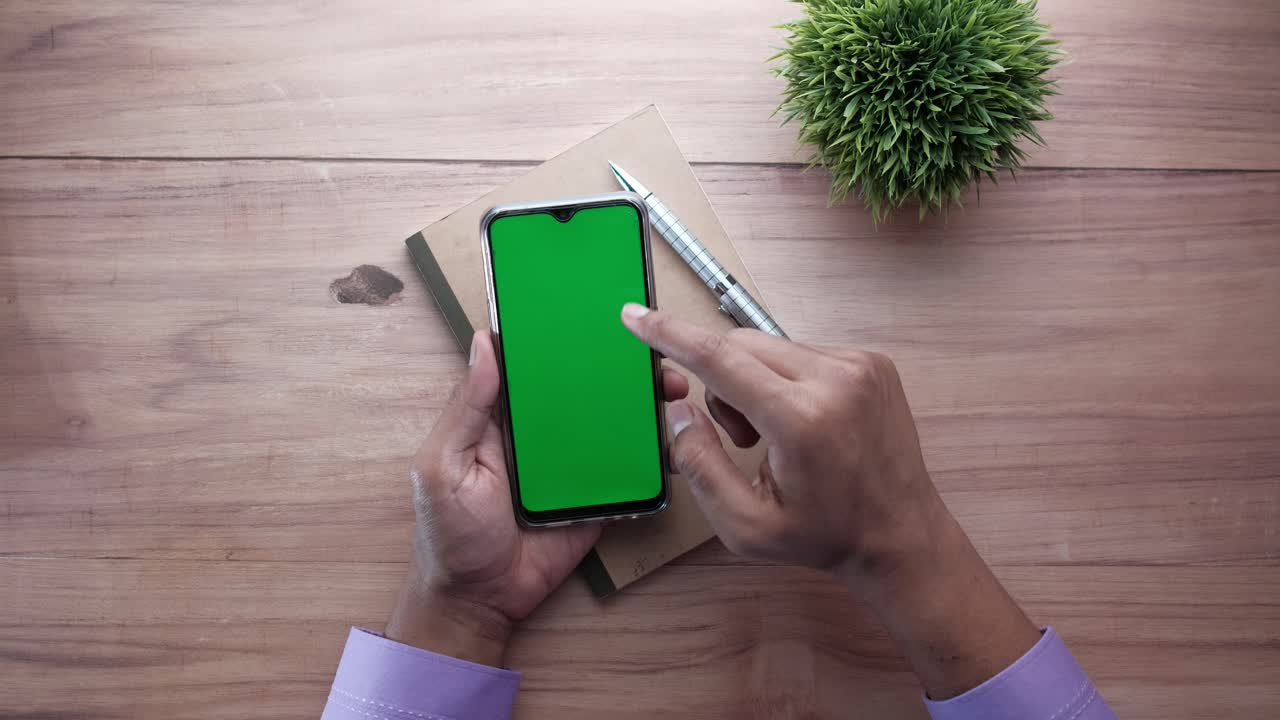 Persona che usa uno smartphone con schermo verde