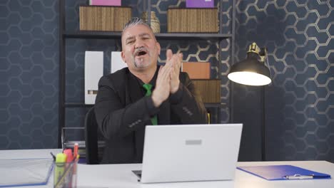un hombre de negocios emocionado aplaudiendo a la cámara.