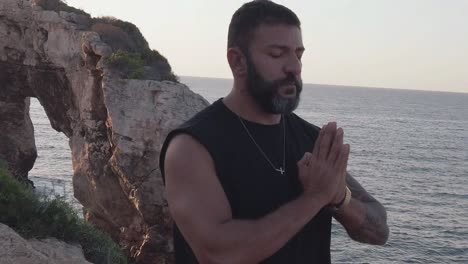 man meditating in a gazebo by the sea