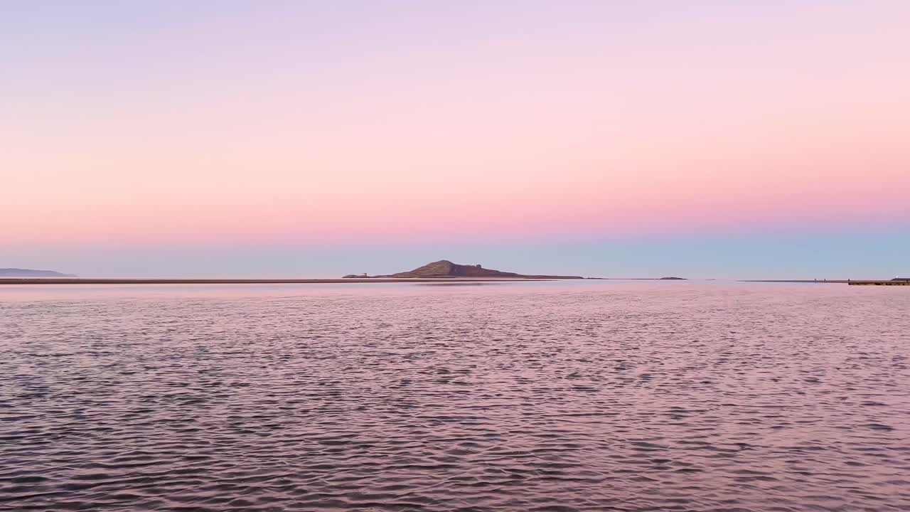 Sunset over a Calm Sea with a Distant Island