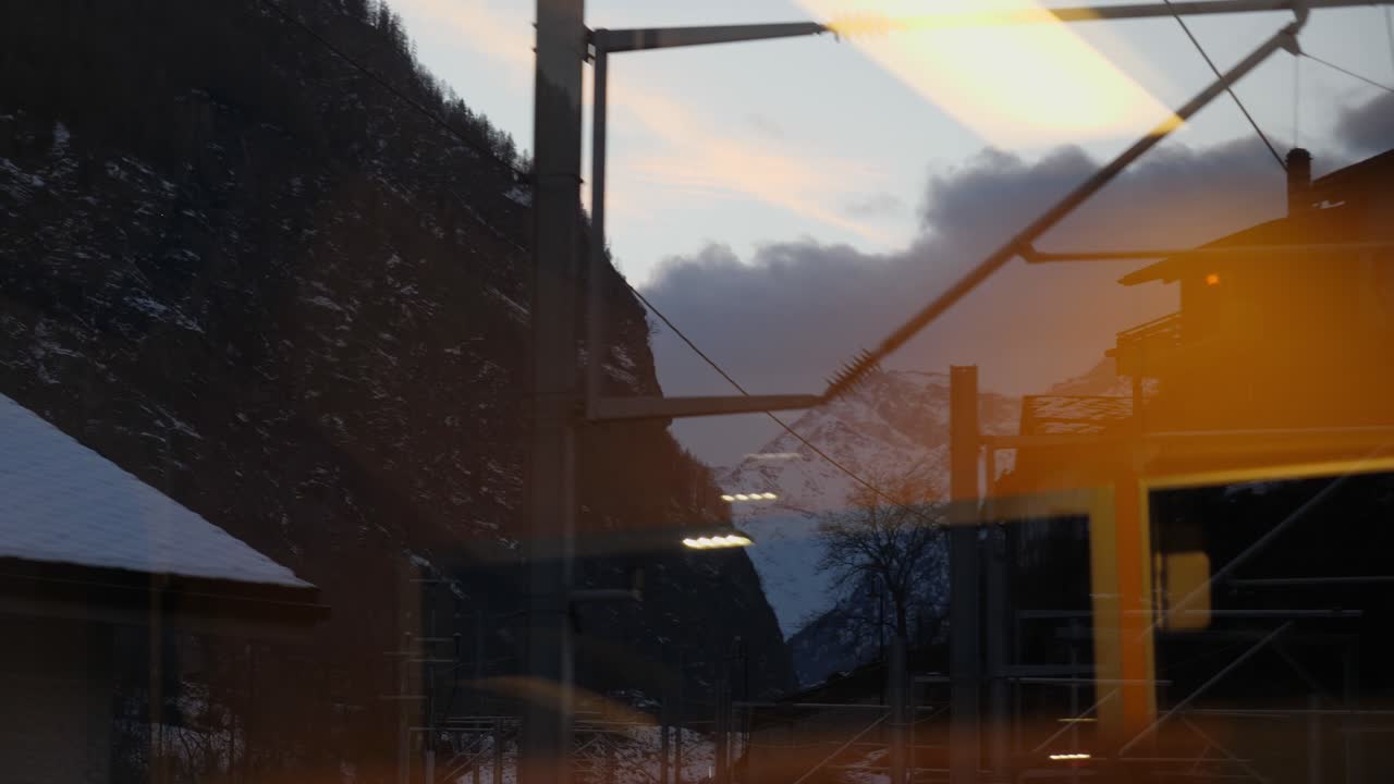 por la ventana, tiro en movimiento que captura los postes de luz y las montañas en basilea