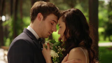 affectionate man kissing woman in forehead outdoors. couple posing in garden