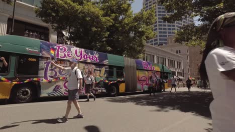 king county metro employees participating in the seattle lgbtq parade, waving rainbow flags