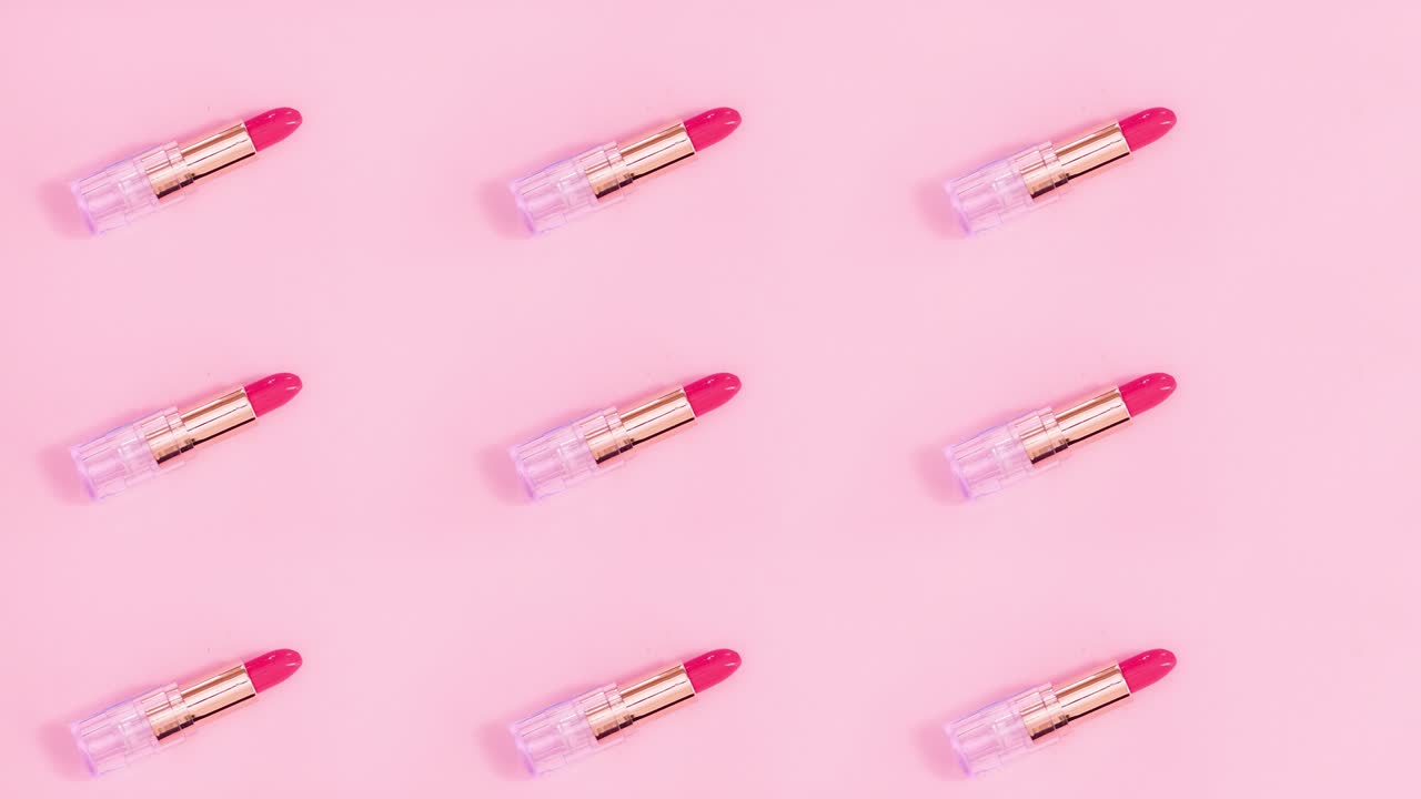 Creative make up pattern made of moving pink lipsticks on pink theme. Stop motion