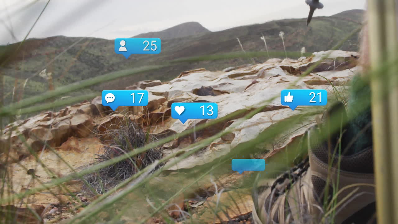 Social media notifications animation over rocky landscape with grass and mountains