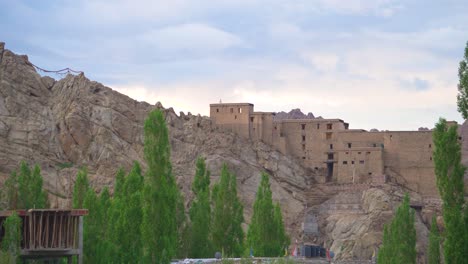 Pan-shot-of-Leh-Palace-or-Fort-and-trees-with-Upper-Himalayas-landscape-of-Leh-Ladakh-India