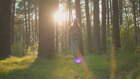 young woman with backpack walks through peaceful forest, bathed in soft, warm evening light, her thoughtful expression as she moves among tall trees and lush greenery