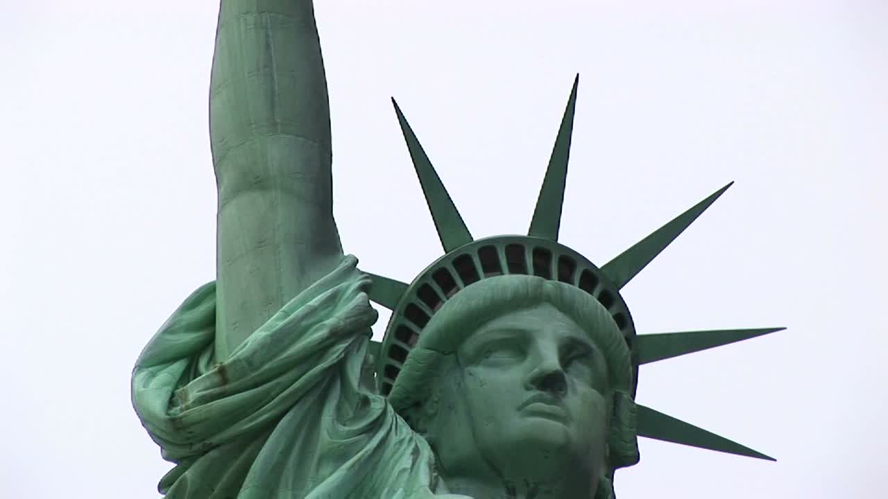 카메라가 자유의 여신상의 머리와 면류관에서 성화까지 패닝합니다.