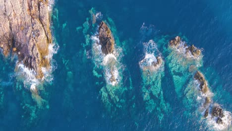 aerial view of rugged rocky islands jutting into deep turquoise waters, creating stunning natural formations and waves crashing against the cliffs, showcasing the pristine beauty of tunisia's.