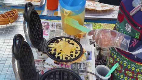 making waffles at a street food stall