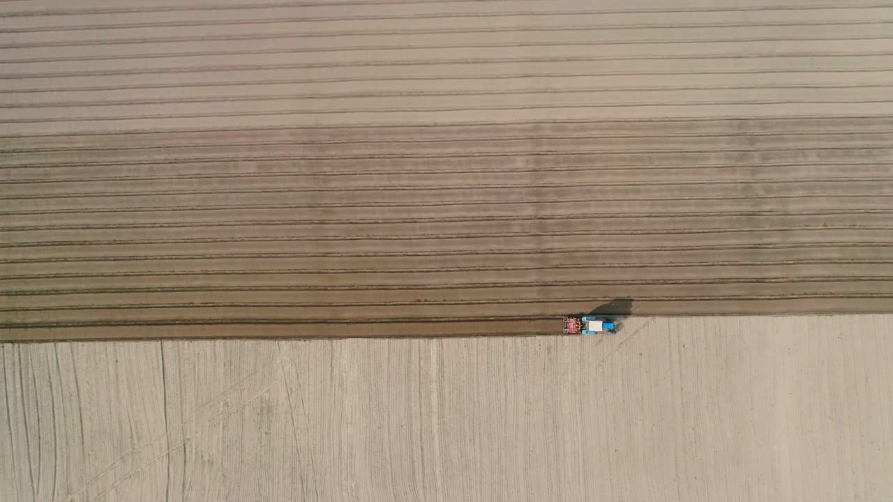 instalación de un sistema de riego en el campo. imágenes aéreas del tractor trabajando en el terreno. siembra de zanahorias