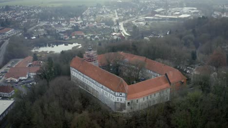 drone aerial view of the traditional german village herzberg am harz in the famous national park in central germany on a cloudy day in winter.