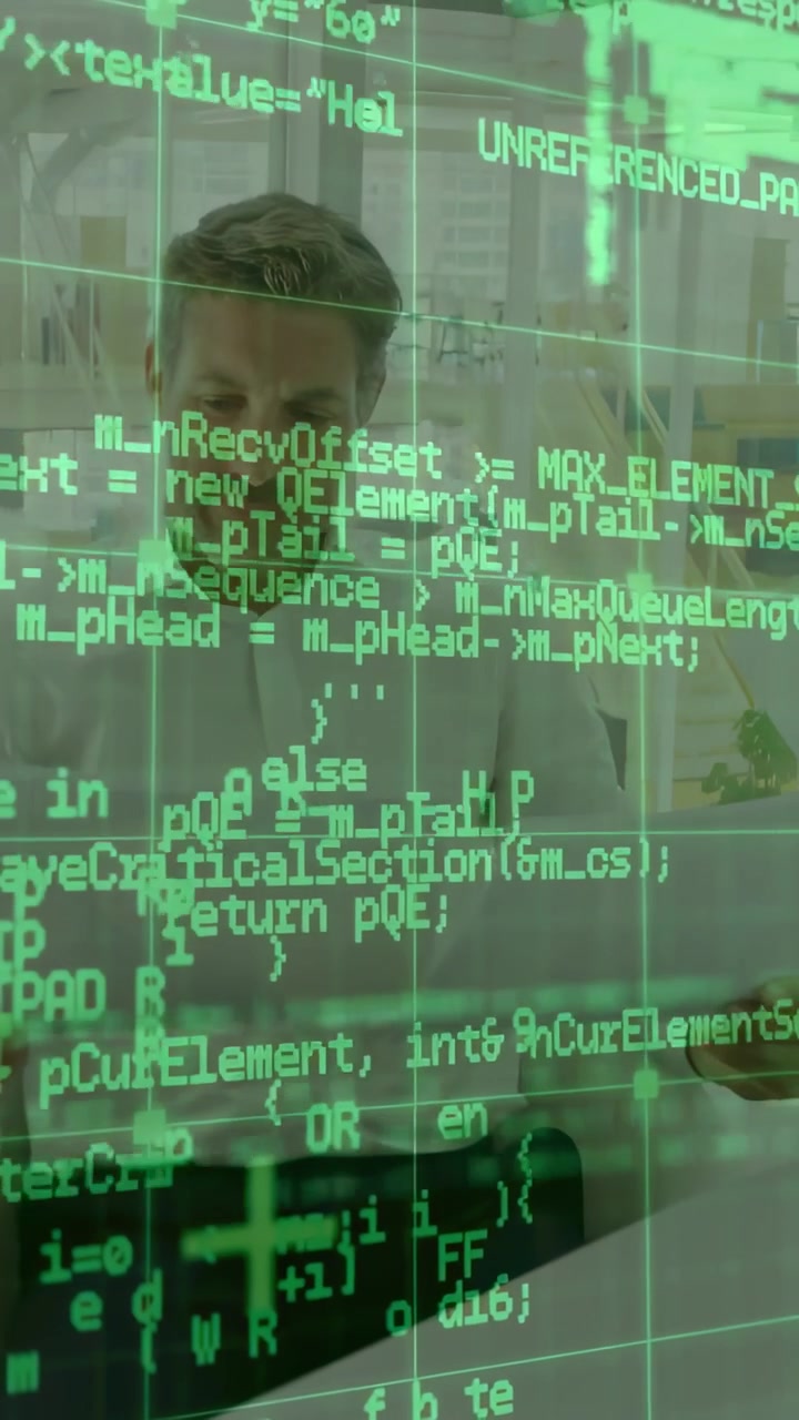 Vertical video: Seated man tapping tablet and reviewing code, causing green code overlay scrolling
