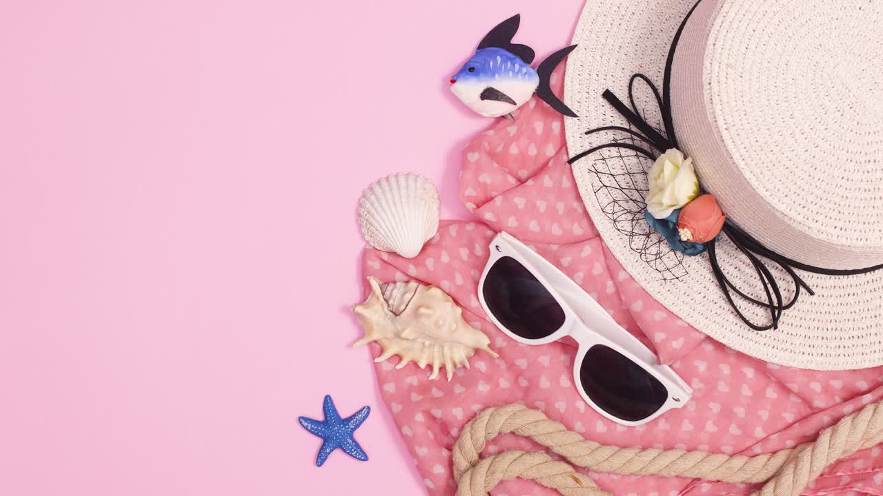 해변 액세서리, 모자, 선글라스, 데기, 로프 및 스카프는 파스텔 분홍색 배경에서 움직입니다.