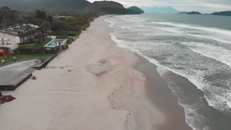 imágenes de drones laterales de la playa, día nublado, olas, mar agitado, paisaje de juquehy, ubatuba, costa norte de são paulo, brasil