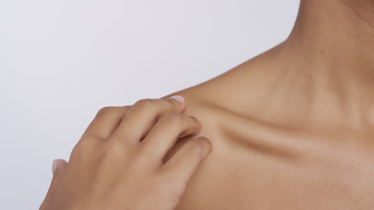 가까이에서 아름다운 아프리카계 미국인 여성이 손으로 얼굴을 만지며 부드러운 건강한 피부 피부 피부미용을 즐기고  ⁇ 색 배경에서 자연스러운 피부미용 치료를 즐기고 있습니다.