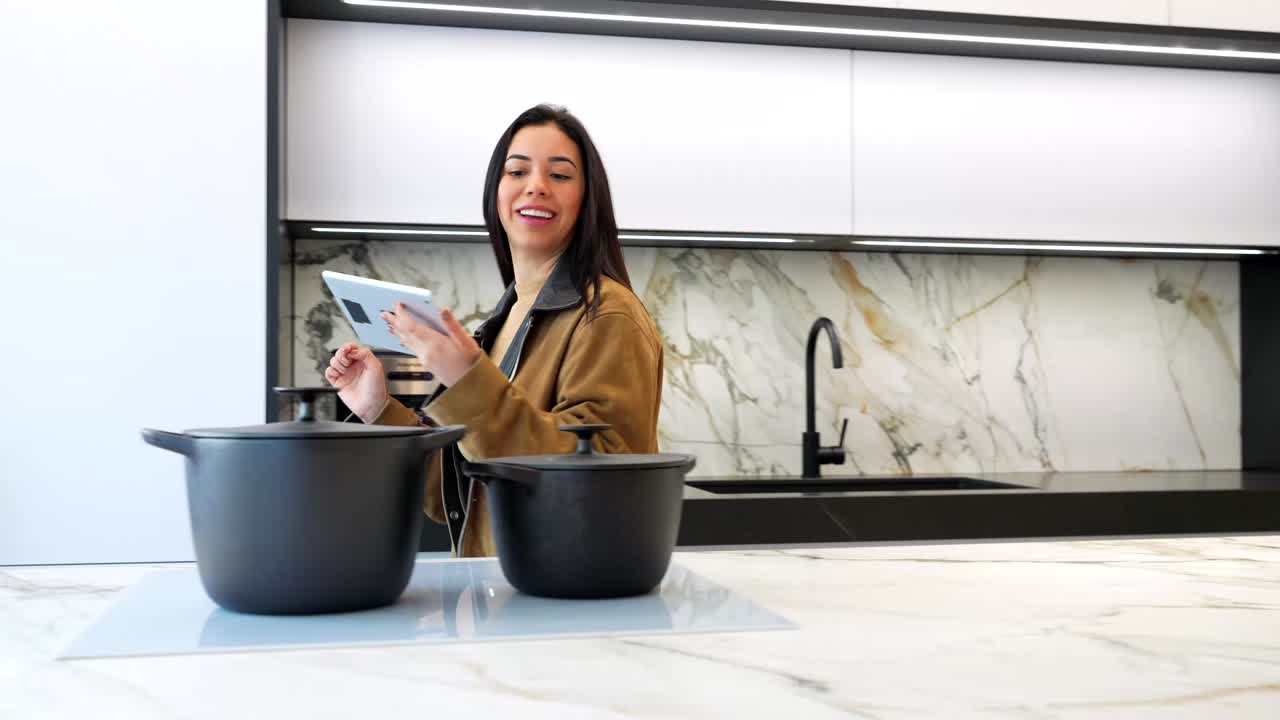 Donna che usa un tablet in una cucina moderna con utensili da cucina