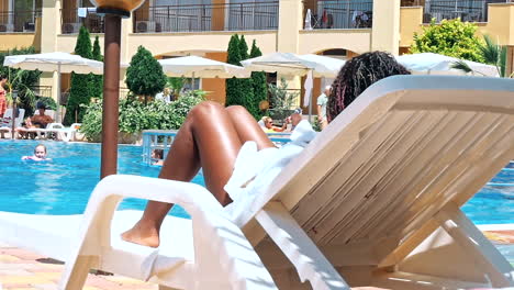 people sitting by the poolside of a resort swimming pool