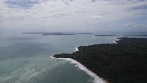 Vista-Aérea-De-La-Costa-De-Bocas-Del-Toro-Bordeada-De-Exuberante-Vegetación-E-Islas-Distantes-Bajo-Un-Cielo-Parcialmente-Nublado