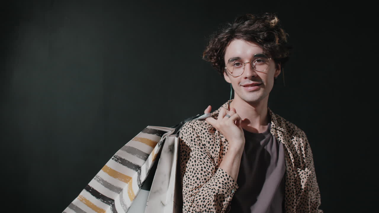 retrato de un joven guapo con bolsas de compras