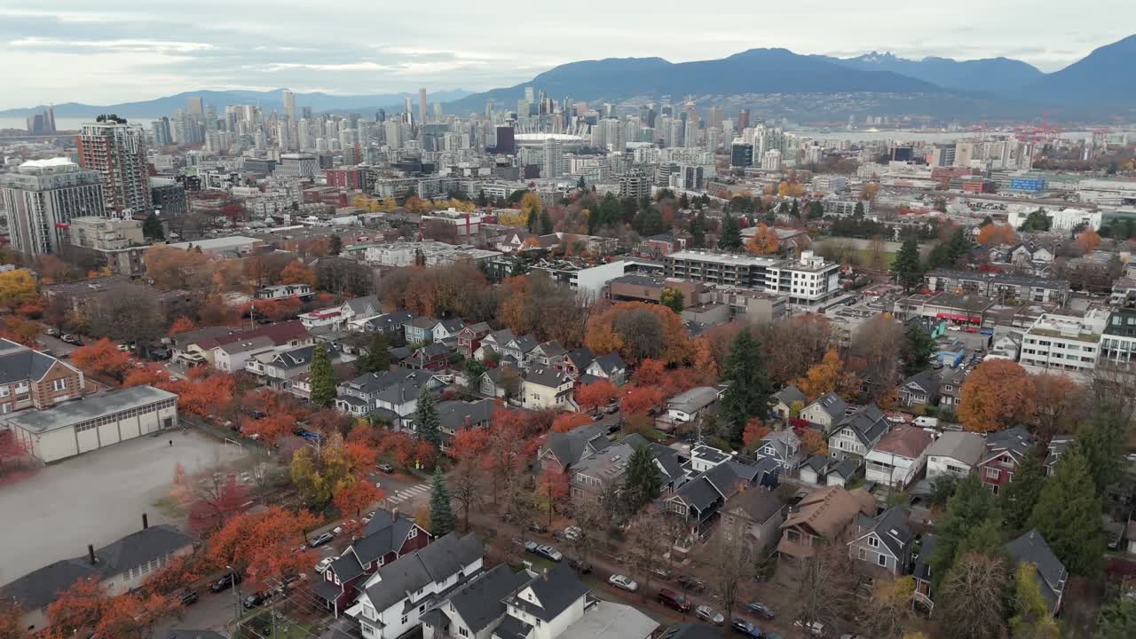 Mount Pleasant Neighborhood With Autumn Foliage, With Vancouver's Downtown Skyline And North Shore Mountains In Background. aerial orbiting shot