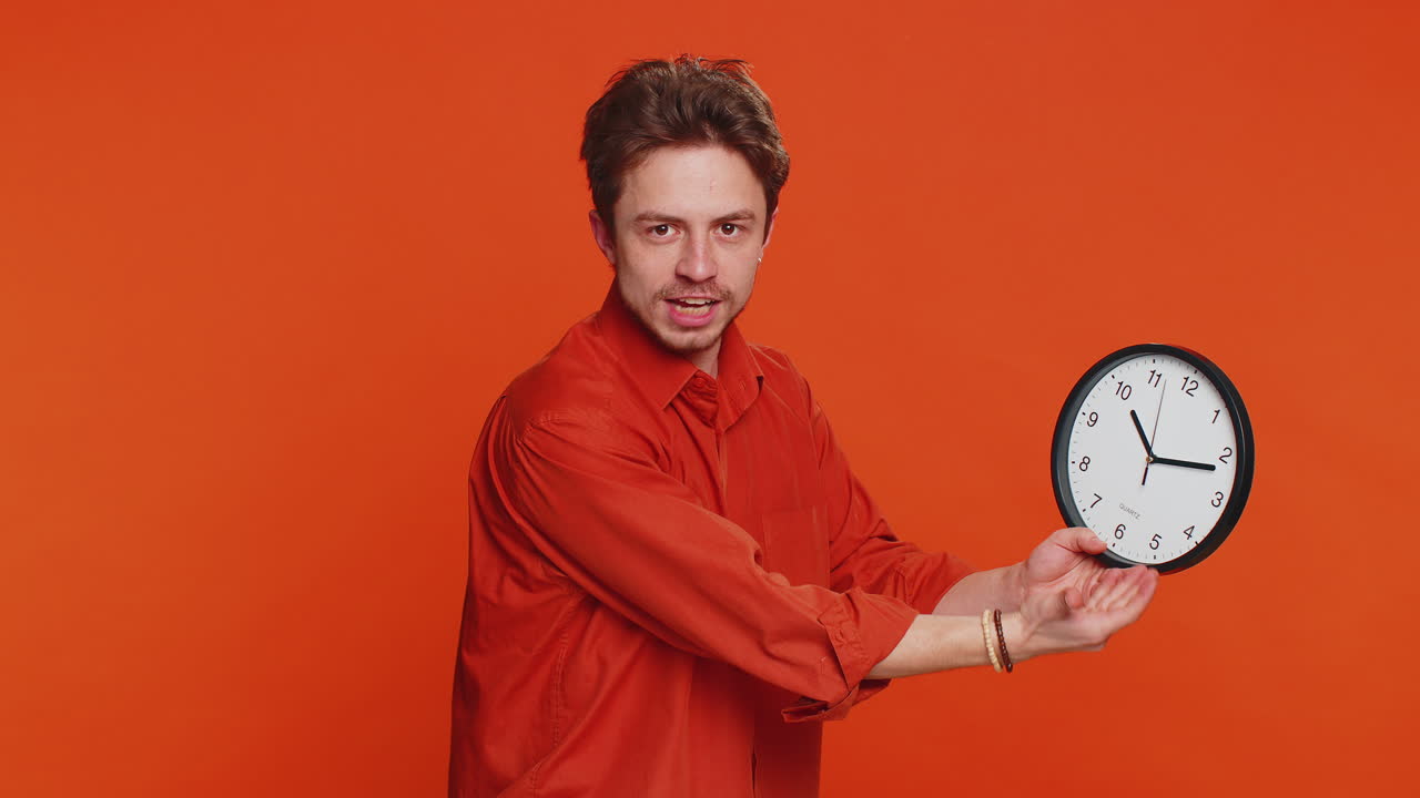 Caucasian man showing time hour on wall office clock ok thumb up approve hurry up deadline