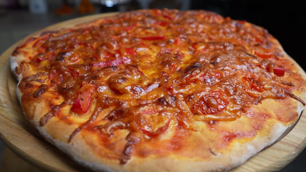 부에서 회전하는 나무 테이블에 치즈, 토마토 및 고추와 함께 피자