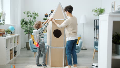 mother and son building cardboard rocket