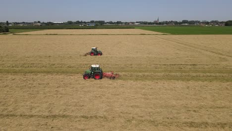 Two-tractors-are-making-hay-on-a-meadow-in-the-Netherlands